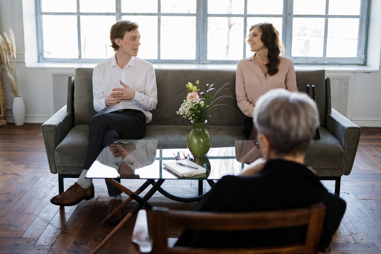 about-01 Couple engaged in a therapy session with a counselor in a loft setting.